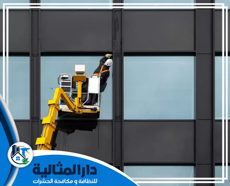 افضل طرق تنظيف وجهات الزجاج بالخبر | 0598198483 | دار المثالية عامل يقف علي رافعه يعمل علي تنظيف واجهات الزجاج بستخدام مواد تلميع الزجاج المتخصص في إزلت الخدوش والاتربة وارجع لمعان الزجاج بالخبر